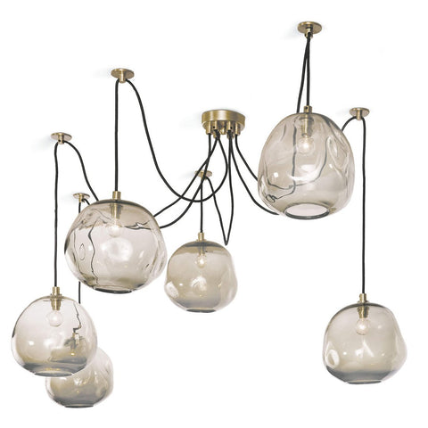 An isolated image of a spider chandelier with 6 bulbs. Each bulb is encased in an irregular glass globe with brass fixtures.